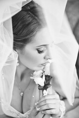 A woman is wearing a veil and holding a rose