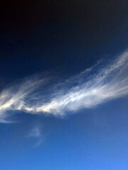 Obraz premium Close up of atmospheric blue black sky with whispy white clouds