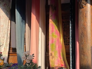 Natural plant - dyed fabrics using a traditional dyeing method hang to dry in sunlight, showcasing...