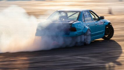 Car drifting, Blurred image diffusion race drift car with lots of smoke from burning tires on speed track, Car drifting on speed track. © Kalyakan