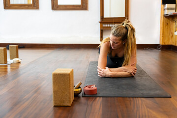 Yoga instructor resting on mat after meditation session in studio