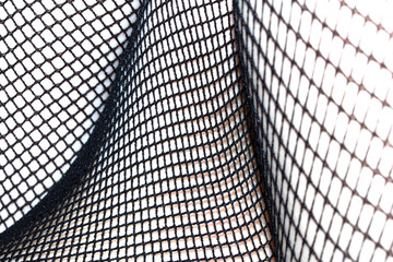 Close up of black fishnet tights on skin legs curves abstract background