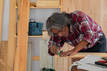 Senior people retirement lifestyles concept, Asian senior carpenter using planer in carpentry...