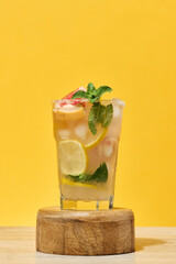 Glass with a cold drink, grapefruit slices, ice, mint and lemon