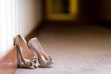 Elegant high heels on a hallway floor. Beautiful high-heeled shoes are placed gracefully by a...