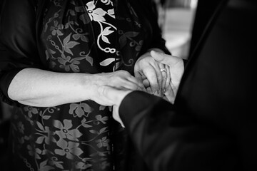 Couple exchanging rings. Two hands clasp as a couple exchanges rings, symbolizing their heartfelt...