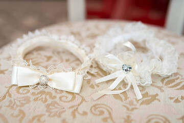 Lace bridal accessories. Two delicate bridal accessories on a lace-covered table, featuring white...