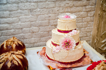Elegant wedding cake with floral accents. A three-tiered wedding cake graces a table, surrounded by...