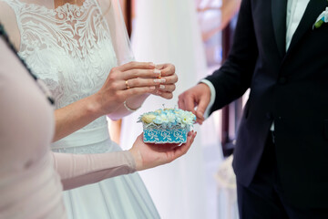 Rings and flowers ceremony. Wedding ceremony showing a bride and groom exchanging rings with a floral arrangement at the center.
