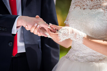 Couple swaps wedding rings. A couple exchanges rings in an outdoor wedding, capturing a moment of...
