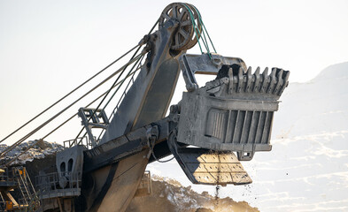Enormous excavator in action at open coal mine during closeup
