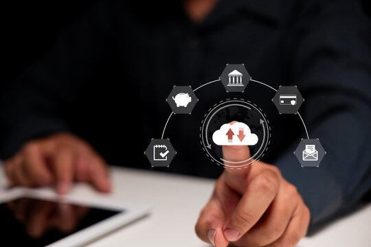 A person interacts with a virtual cloud icon displaying upload and download arrows, surrounded by finance and data management symbols on a dark background.