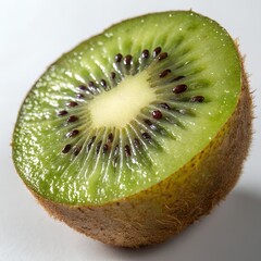 A cut kiwi fruit isolated on white background shows its green flesh and black seeds