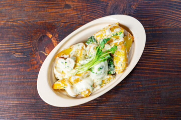 Delicious baked potatoes topped with creamy sauce and fresh broccoli in a cozy restaurant setting