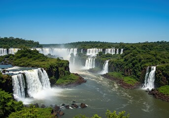 Fototapeta premium The breathtaking Iguazu Falls cascade powerfully amidst lush green surroundings.