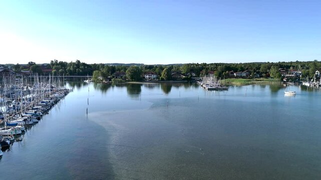 Wundervolle Sommerlandschaft am Chiemsee aus der Drohnenperspektive mit Seegelboten im Hafen