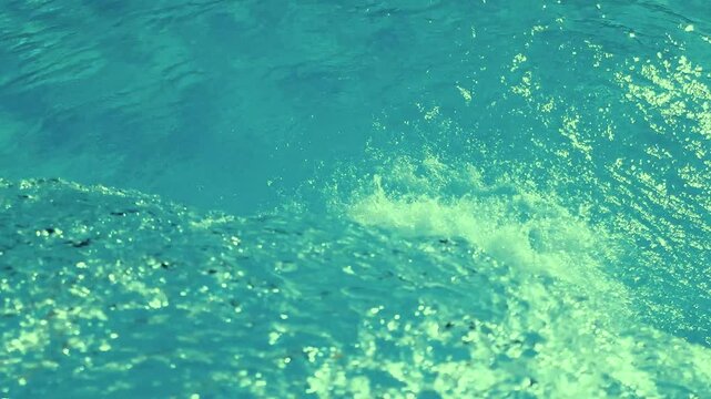 Slow motion video of green clear water falling into a swimming pool