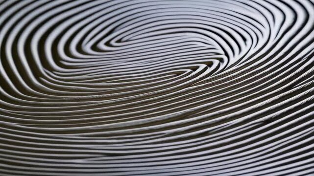 Close-up of textured abstract pattern of curving parallel lines with subtle shadows in a spiraling formation for artistic backgrounds