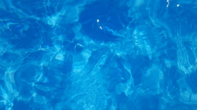 Background blue water movement with top view close up in swimming pool. Slow motion video.