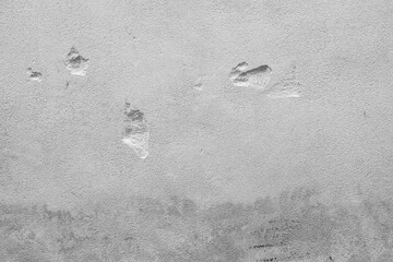 Light gray concrete surface with subtle indentations, scratches, and irregular rough texture