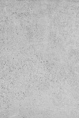 Rough gray concrete surface with porous texture, speckled marks, and subtle tonal variations.