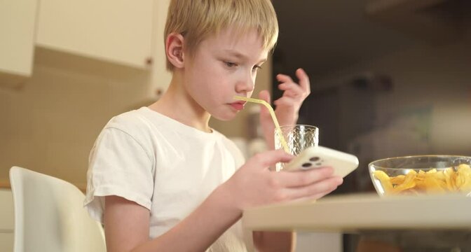 A little boy enjoys his breakfast at the kitchen table in a natural, authentic moment. Candid emotions, messy hair, and genuine childhood joy make this scene heartwarming