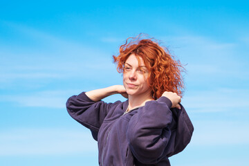 Portrait of red-haired curly young woman in sportswear.