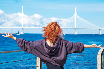 Energetic red-haired curly young woman in sportswear swinging her arms.