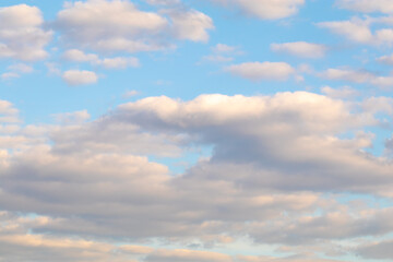 Soft pastel clouds in blue evening sky.