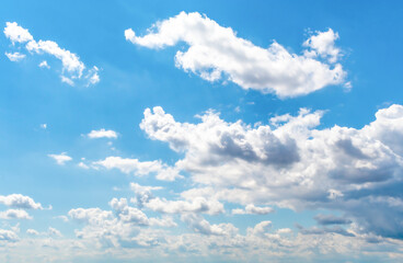 Bright blue sky with white fluffy clouds.
