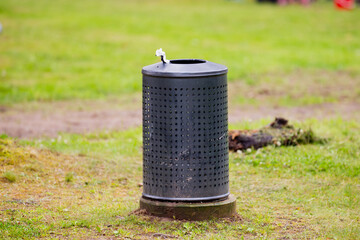 metal trash bin in public park on green grass waste container outdoor garbage can in city park...