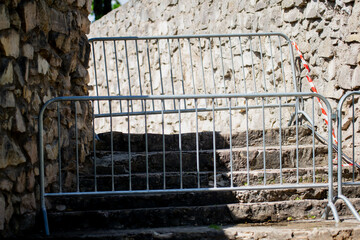 temporary metal barricade blocking stone staircase entrance for restricted access or event crowd...