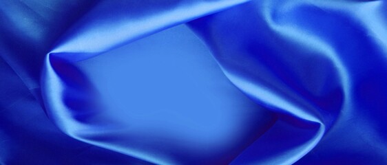 Blue silk background. The folds of the fabric create an abstract place for the text.