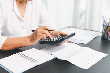 Using calculating machine, household carefully manages each bill and expense to plan financial budget, ensuring timely payment, consistent saving, smart investment for secure home finance strategy.