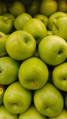 Close up pile of tasty fresh apples sold at the market as a background.