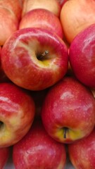 Close up pile of tasty fresh apples sold at the market as a background.