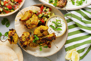 Persian chicken kebab with yogurt sauce, pitas and shiraz vegetable salad.selective focus