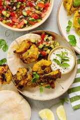 Persian chicken kebab with yogurt sauce, pitas and shiraz vegetable salad.selective focus