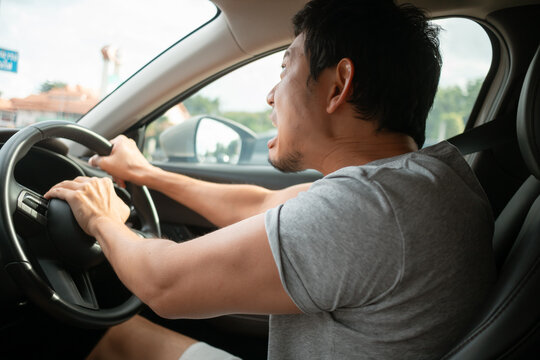 Angry Asian man reacting strongly honk the horn while driving car