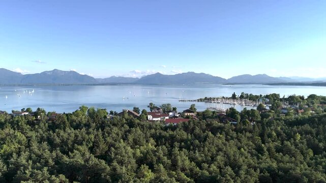 Wundervolle Sommerlandschaft am Chiemsee aus der Drohnenperspektive mit Seegelboten im Hafen