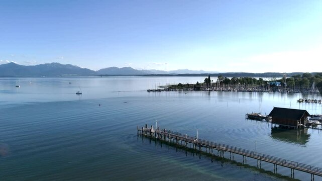 Wundervolle Sommerlandschaft am Chiemsee aus der Drohnenperspektive mit Seegelboten im Hafen