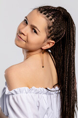 A Stylish Young Woman with Beautifully Braided Hair Posing in an OffShoulder Top