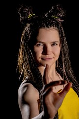 A youthful woman wearing yellow with a playful expression that exudes joy and liveliness