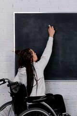 An Empowered Individual in a Wheelchair Passionately Writing and Expressing Ideas on a Chalkboard