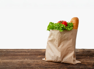 Paper bag with fresh vegetable and bread on vintage table.
