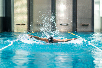 Swimmer doing exercise in indoor swimming pool.