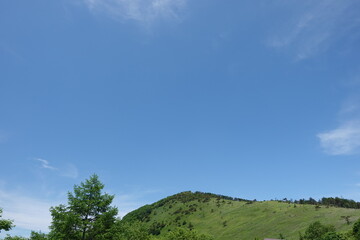 青くて広い夏の空と緑色の山