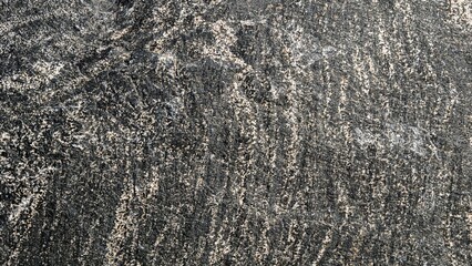 Dark stone surface showing rough texture with golden streaks