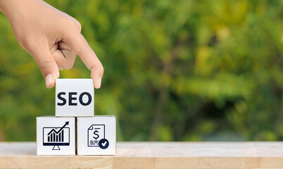 Hand placing SEO block on top of block showing analytics and secure transactions