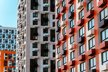 Fragments of multi-storey residential buildings against the background of a blue sky. Modern...